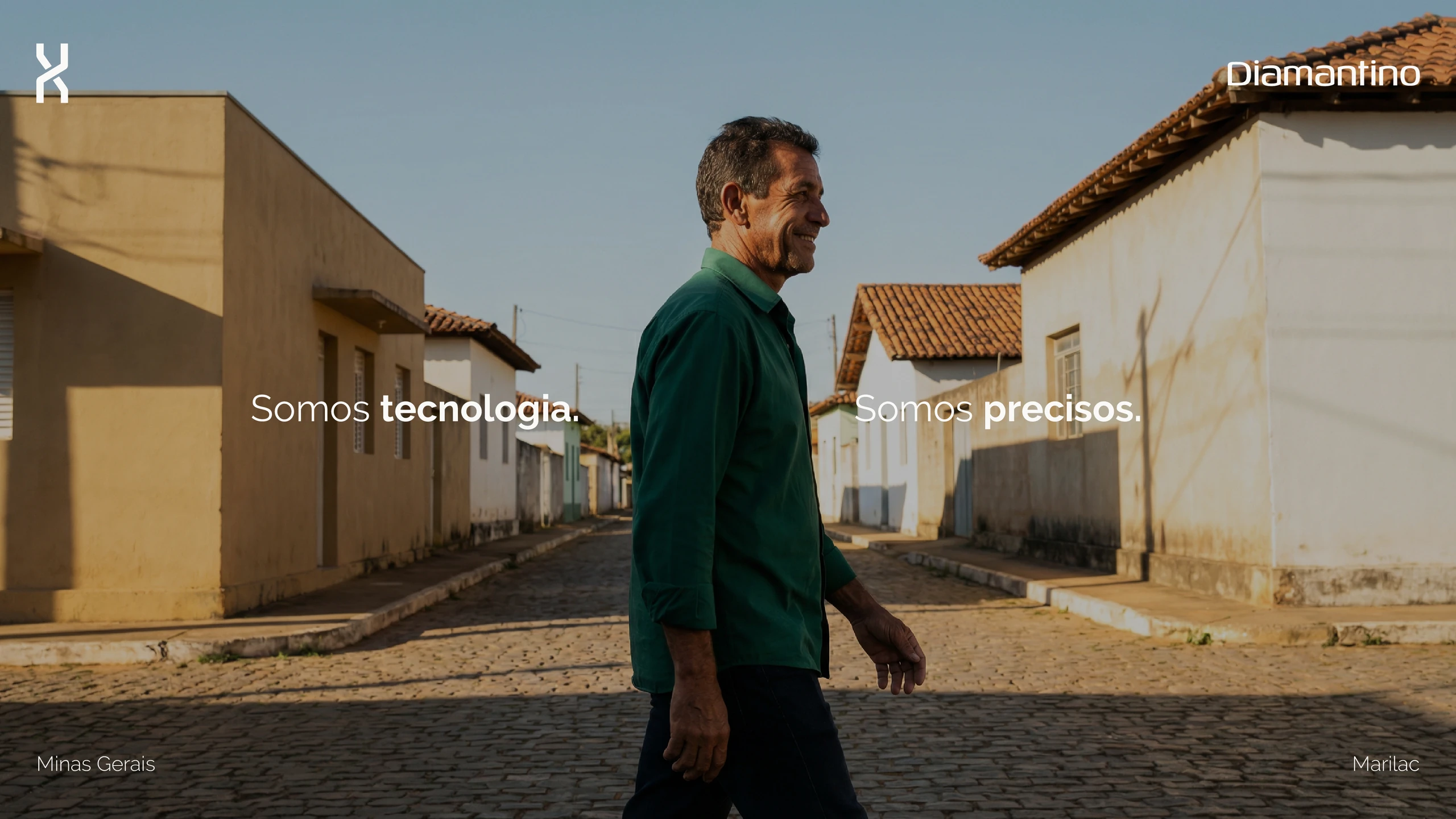 Homem caminhando por uma rua do interior, com a frase “Somos tecnologia. Somos precisos.”