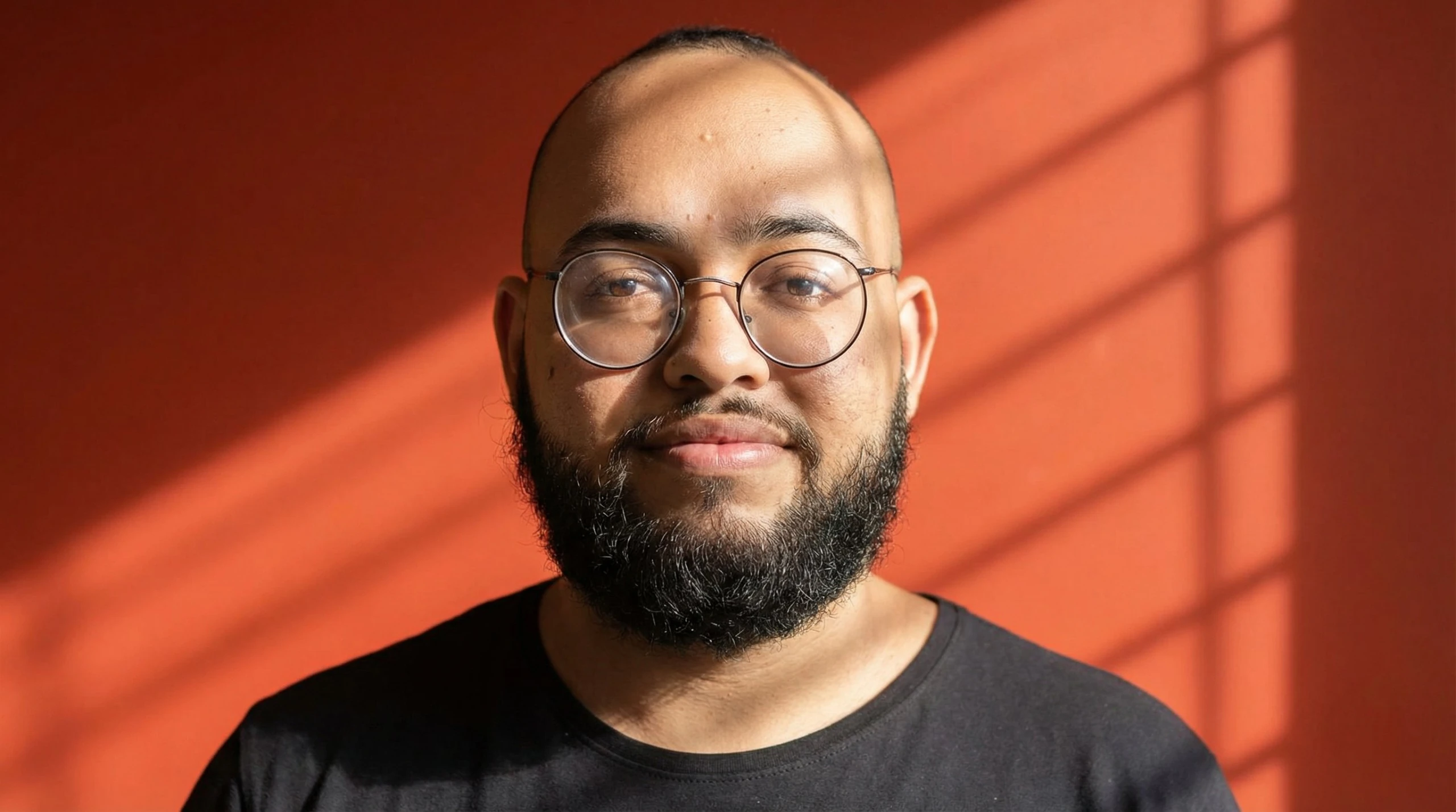 Marlon Fernandes, fundador da Londe, de frente, em fundo laranja com luz natural de janela